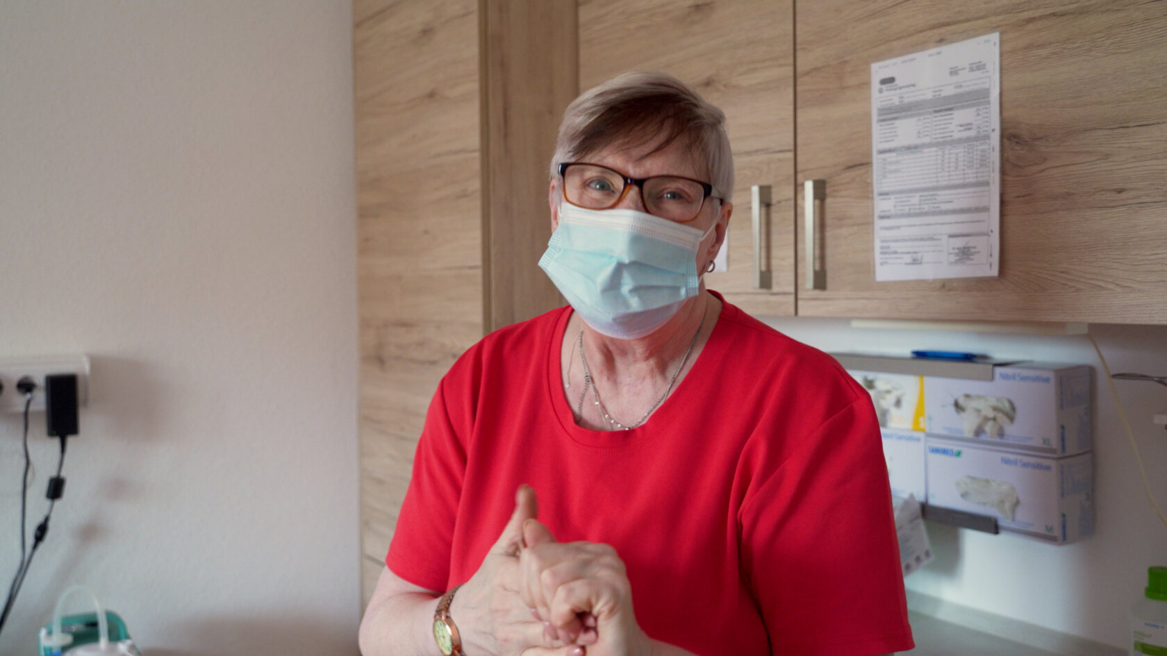 Foto aus Video 3 Pflegefachkraft mit medizinischer Maske bei der Arbeit